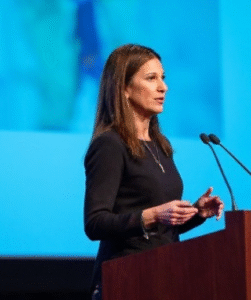 Laura Speaker Photo on Stage Podium Blue