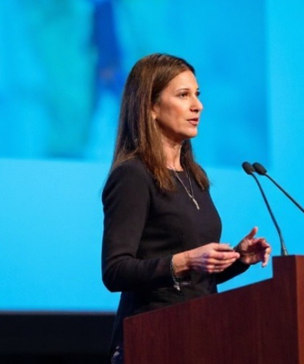 Laura Speaker Photo on Stage Podium Blue